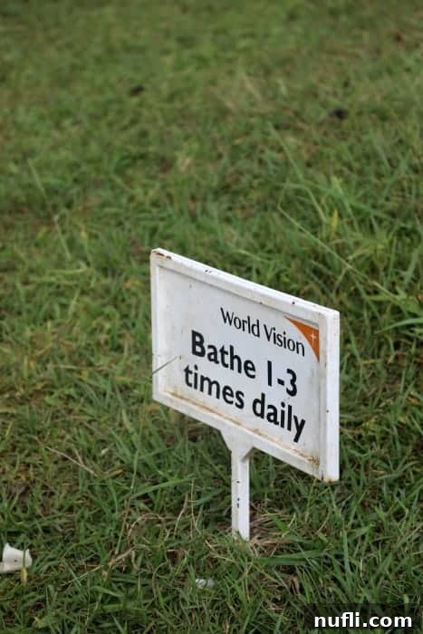 A World Vision sign encouraging regular bathing, promoting personal hygiene among students in Uganda.