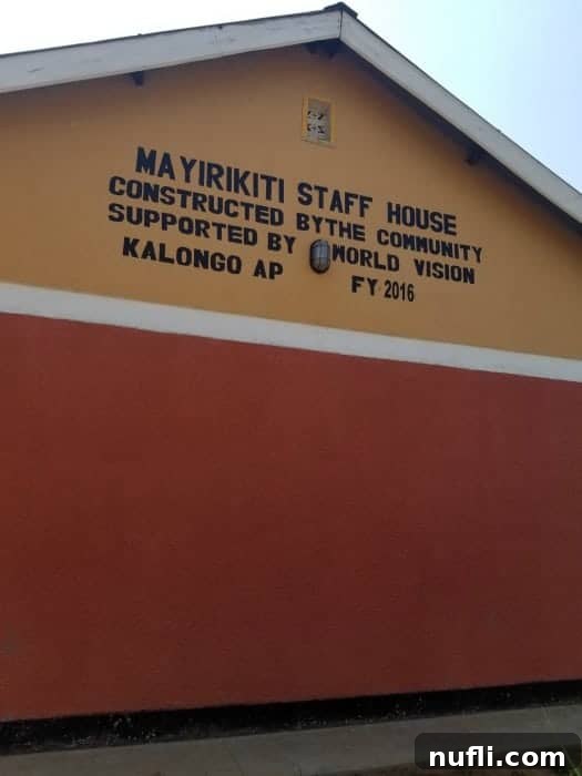 A bright orange and red building serving as staff housing at a Ugandan school, supported by World Vision donations.