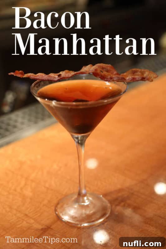 Smoky Bacon Manhattan 2 Bacon Manhattan cocktail in a martini glass, garnished with a strip of crispy bacon. The drink itself has a rich amber hue, suggesting depth and flavor.