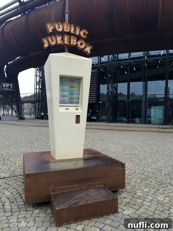 An outdoor public jukebox situated on a platform at the Gong auditorium in Dolní Vítkovice, inviting visitors to play a song.