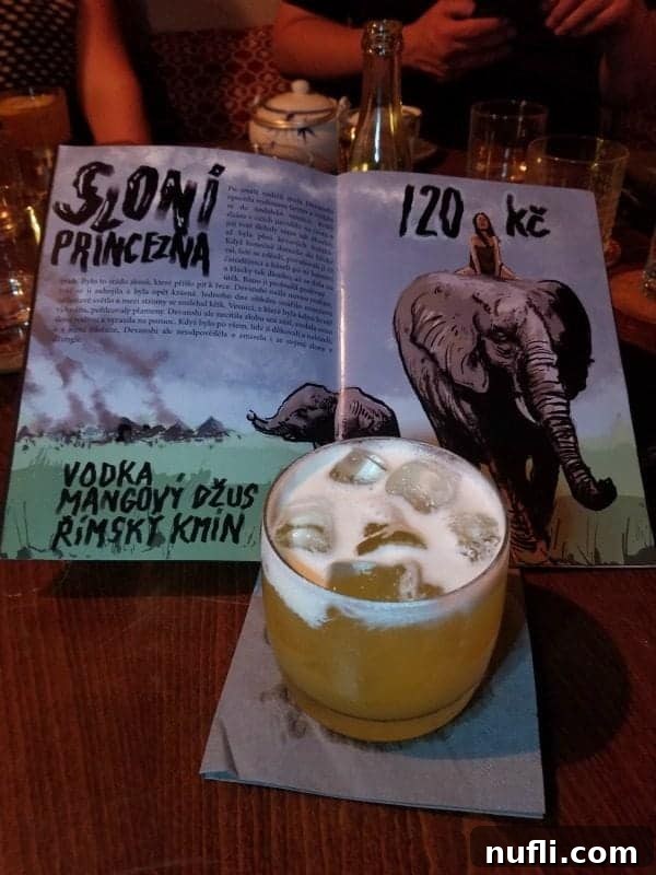 A unique cocktail presented next to a menu featuring an elephant motif, hinting at the intriguing atmosphere of Gustavus the Time Traveler's Speakeasy.