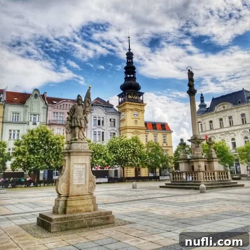 Masaryk Square in Ostrava, bustling with colorful buildings, outdoor cafes, and a prominent statue, capturing the lively atmosphere.