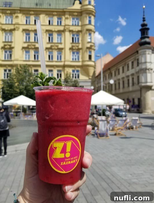 frozen red drink behing held up in the town square 