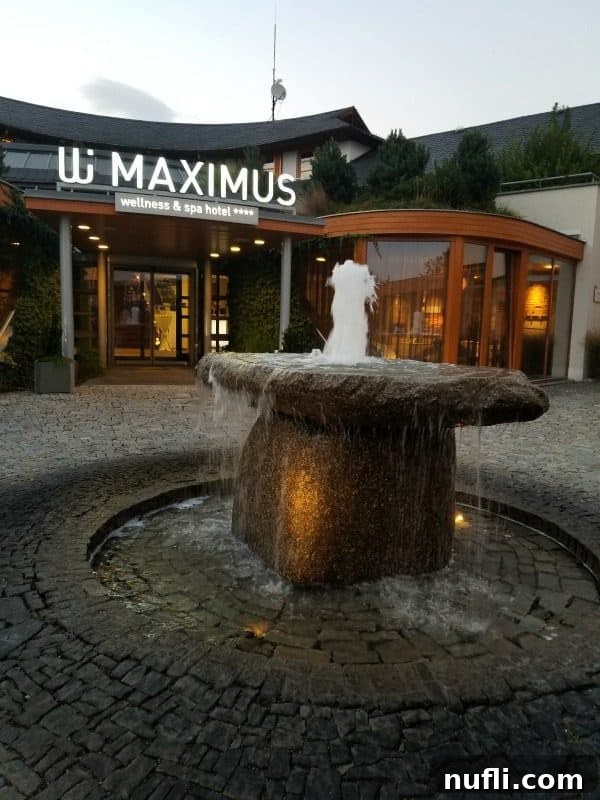 Maximus wellness and spa hotel sign next to a water fountain 