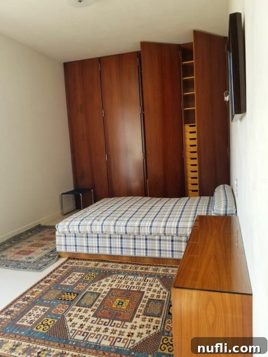 Villa Tugendhat Brnos Modernist Marvel 5 bedroom with plaid comfortor on the bed woven rugs, and wall of closets