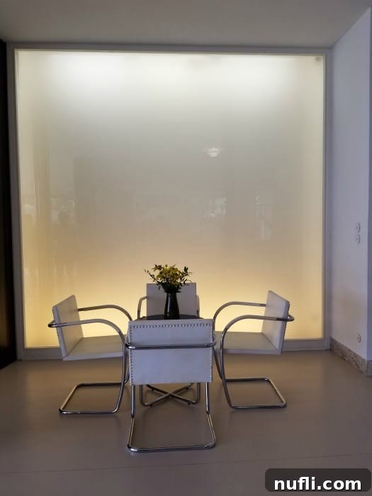 Villa Tugendhat Brnos Modernist Marvel 10 white chairs at a table with a white wall behind it in Villa Tugendhat