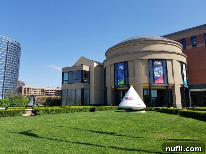 Grand Rapids Museum exterior with green grass lawn, space equipment, and blue skies