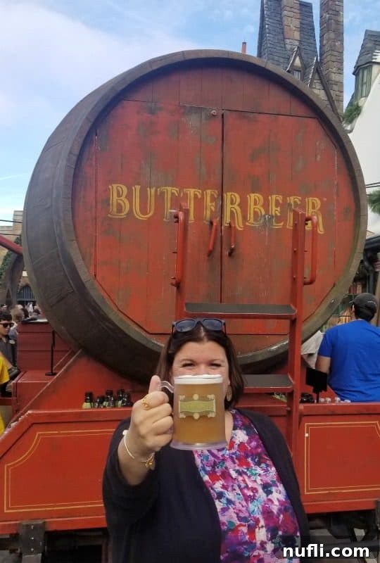 Tammilee holding a butter beer in front o the Butter Beer stand 
