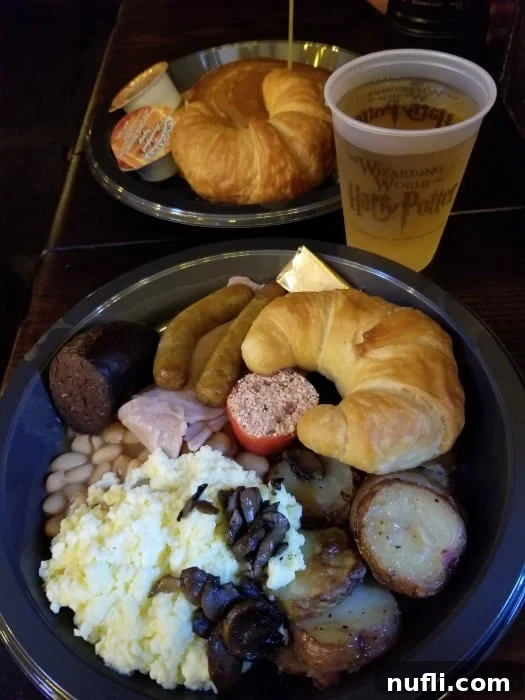 plate nwith bread, sausage, beans, and potatoes next to a Butter beer