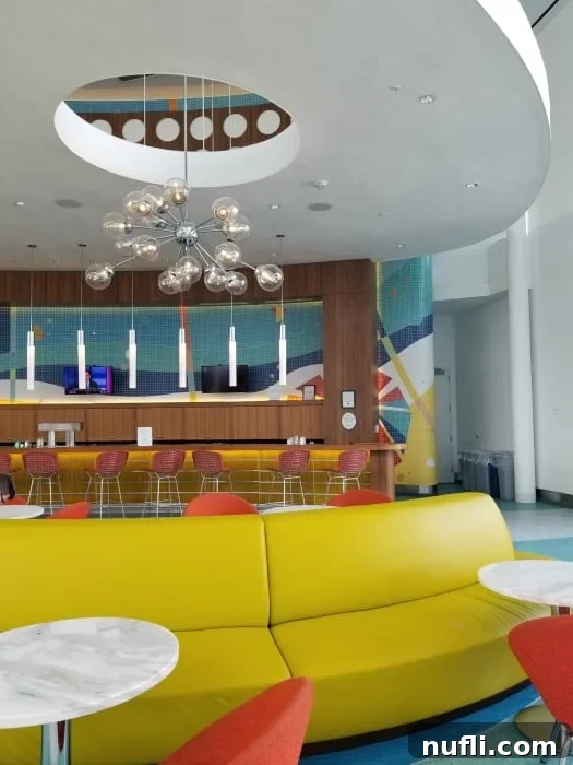 A retro-styled lounge area with yellow sofas, tall bar stools, and a sleek, vintage-looking bar