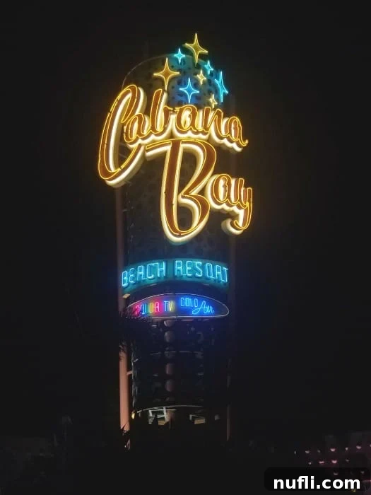 Illuminated neon sign for Cabana Bay Beach Resort glowing brightly against the evening sky