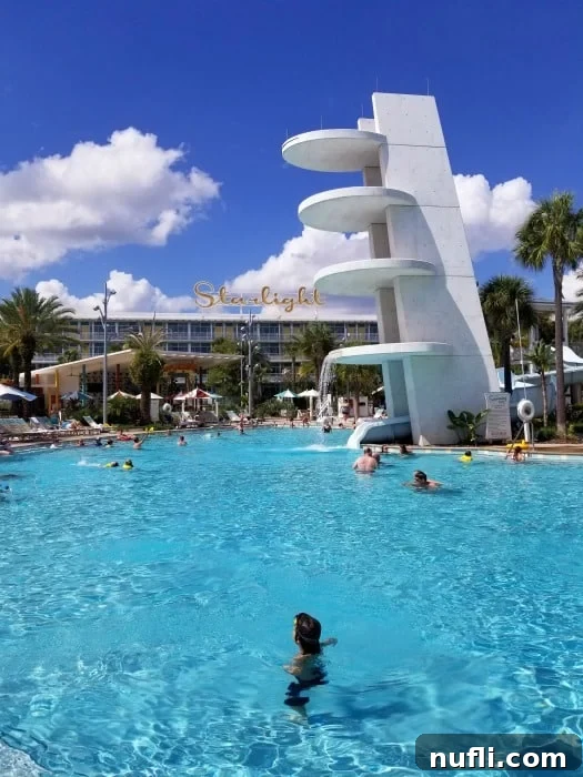 A wide shot of the Cabana Bay Beach Resort main pool on a bright, sunny day, with calm blue water