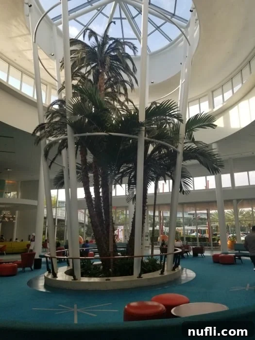 Tall palm trees adorning the expansive and bright lobby of Cabana Bay Resort