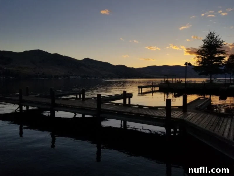 Stunning sunset over Lake Chelan seen from a dock, reflecting vibrant colors on the water