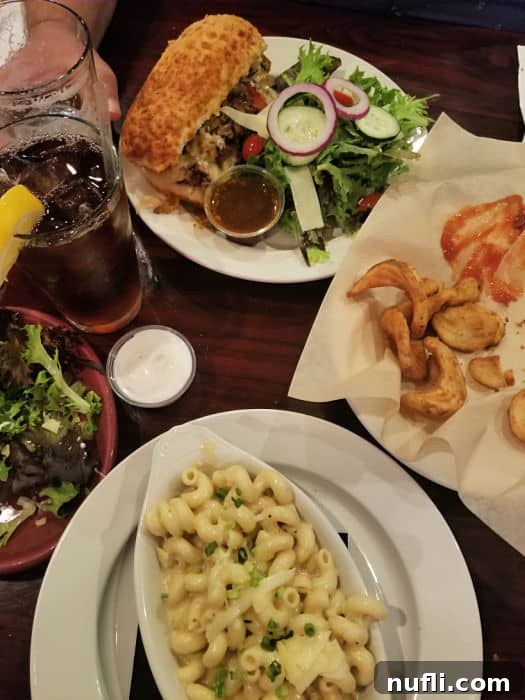 mac and cheese, flries, and a salad on white plates 