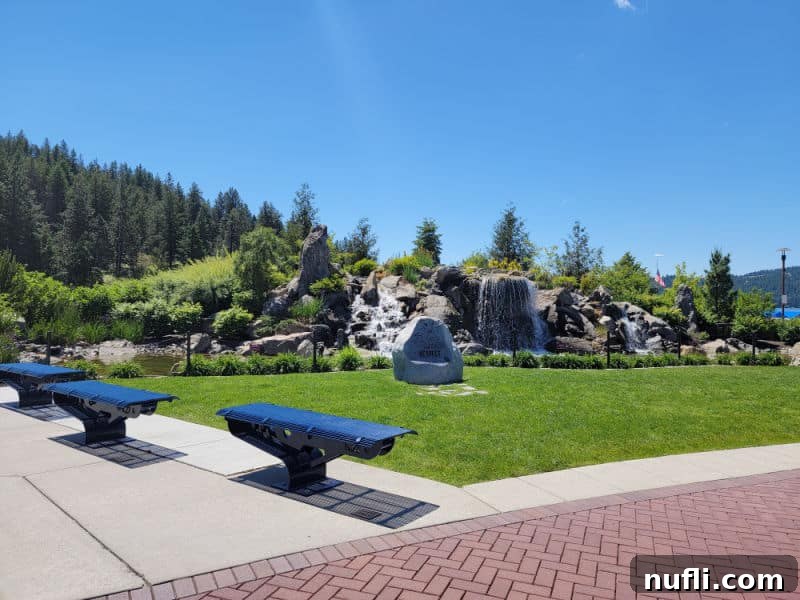 Park area with waterfall in the middle of rocks and benches 