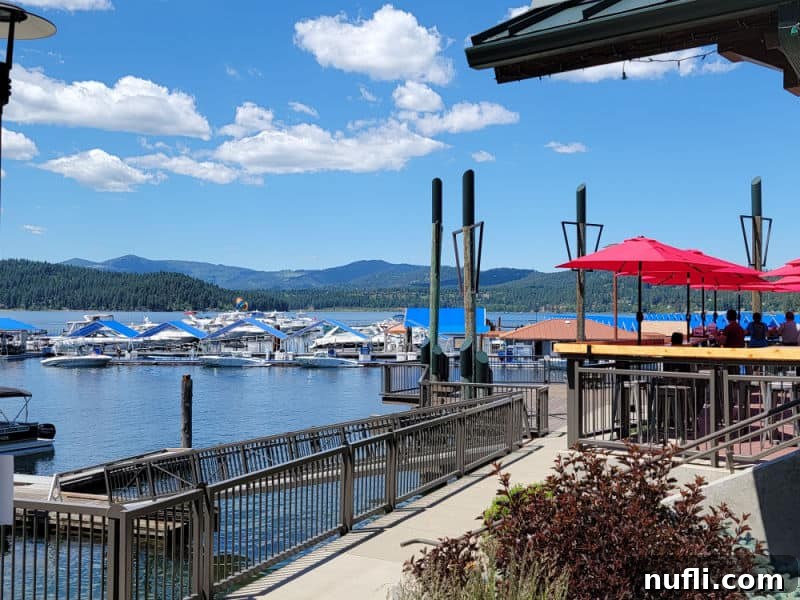 Lake CDA with boats on the water, people eating under red umbrellas