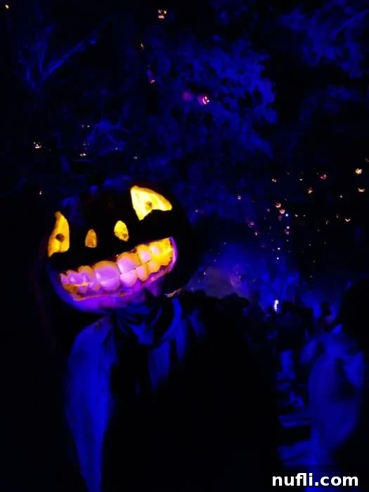 A detailed glowing pumpkin head prop with intricate carving and eerie illumination, enhancing the scare zone ambiance
