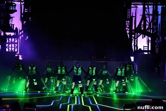 Performers in black and green costumes with neon accents, part of a dynamic stage show