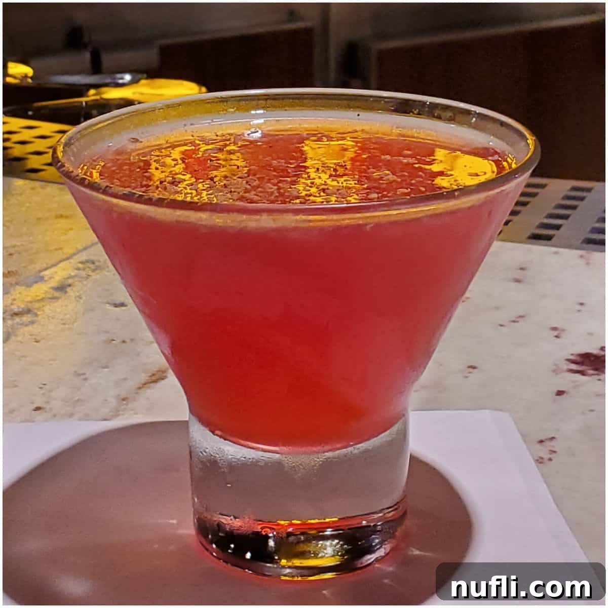 red martini in a stemless martini glass on a white napkin