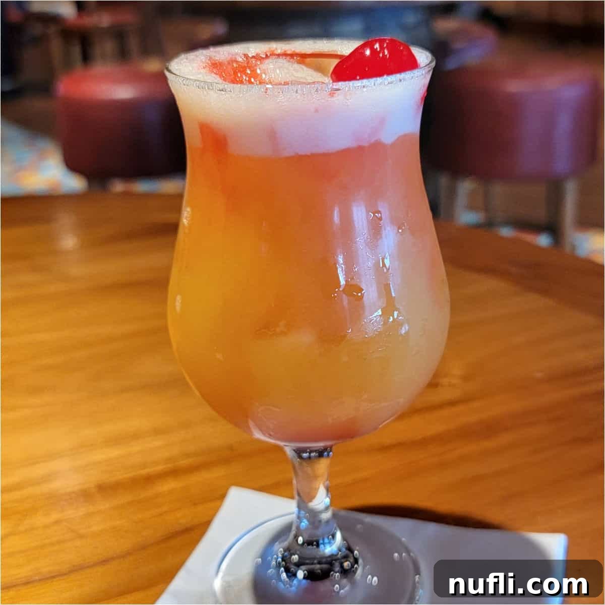 Rump Jumper cocktail in a hurricane glass garnished with a cherry