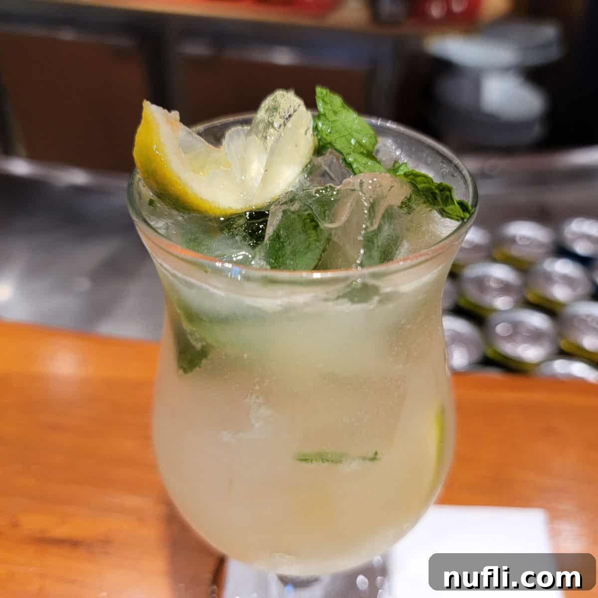 Ting Mojito in a hurricane glass with mint and lemon wedges