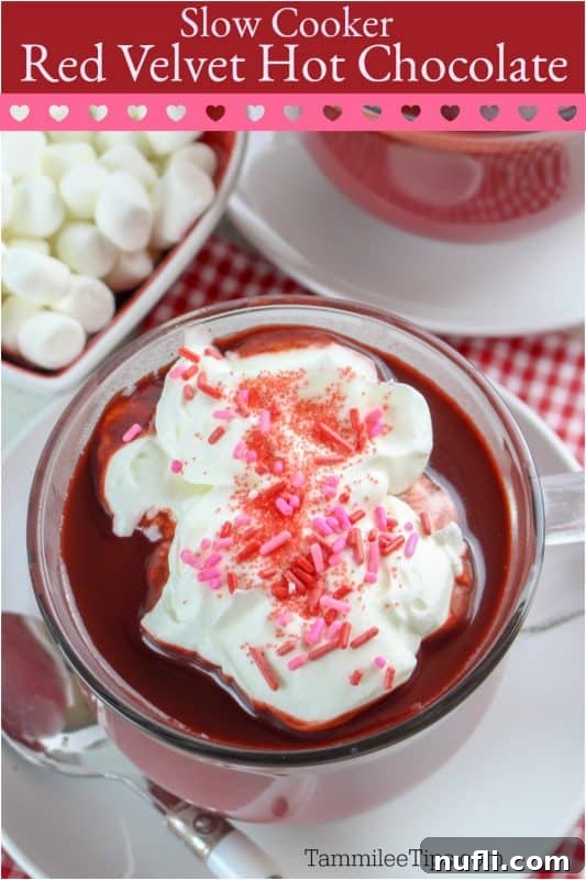 Slow cooker red velvet hot chocolate being poured into a mug, topped with whipped cream and sprinkles.