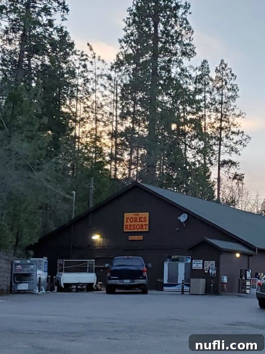 The distinctive sign for The Forks Resort Restaurant on the exterior of a charming brown building, indicating a lakeside dining spot.