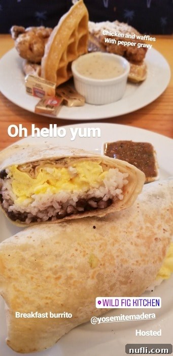 A delicious breakfast burrito presented on a white plate, with chicken and waffles subtly visible in the background, from the Wild Fig Kitchen in Coarsegold, CA.