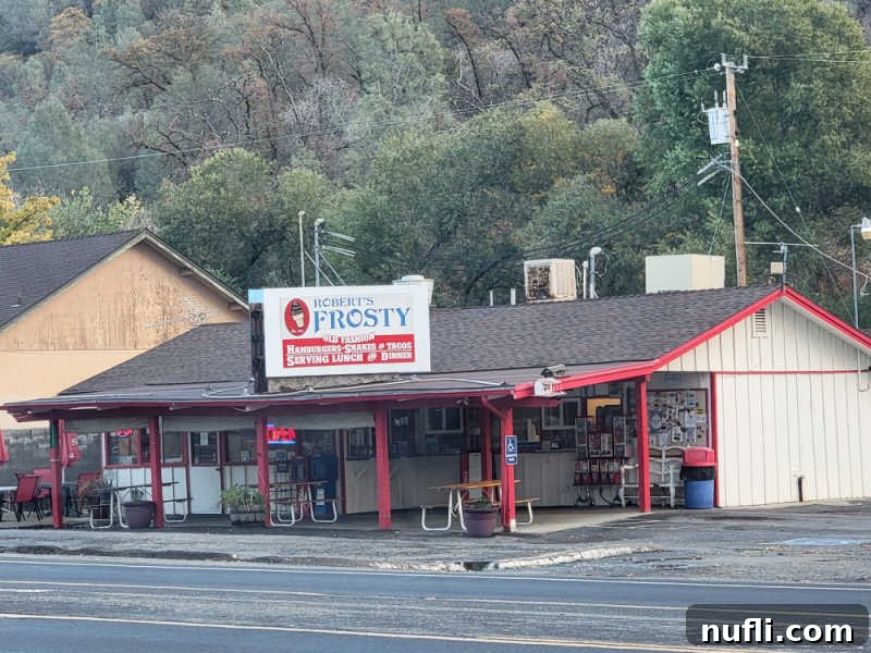 The exterior view of Robert's Frosty, a roadside restaurant, with lush trees in the background.
