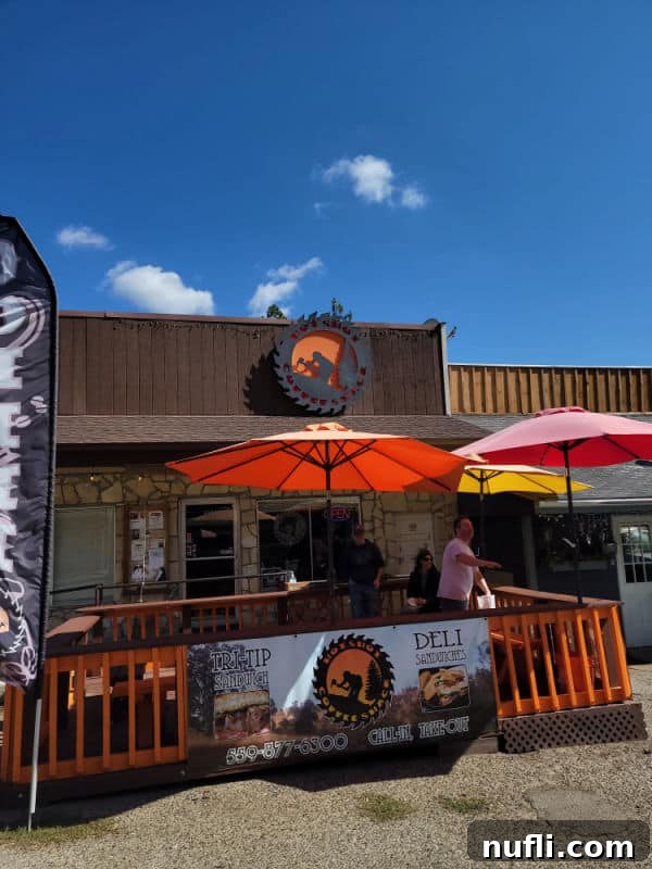 The exterior of Hotshot Coffee Shack, featuring three raised umbrellas and a restaurant sign on the fence, providing a welcoming outdoor setting.