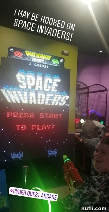 Tammilee playing Space Invaders at Cyber Quest arcade