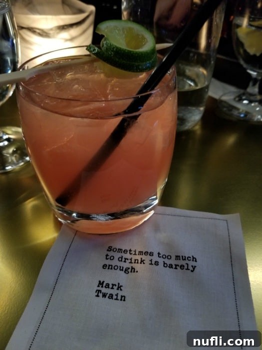 Elegant cocktail on a branded napkin with a quote