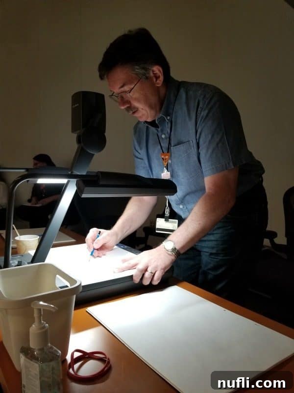 Legendary Disney animator Mark Henn drawing on a board at a Disney event