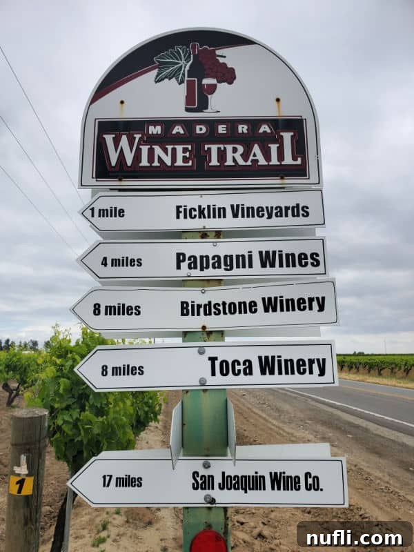 Madera Wine Trail signpost, indicating miles to multiple vineyards, guiding visitors along the trail.