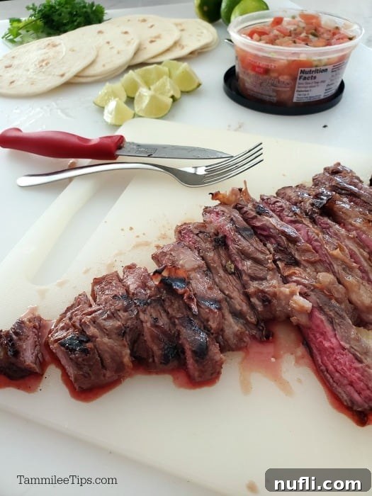 Ultimate Carne Asada Street Tacos 3 Carne asada cut into pieces on a cutting board next to salsa, lime wedges and soft street taco shells, ready for assembly.