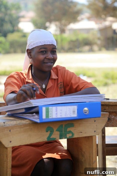 student at a desk in uganda