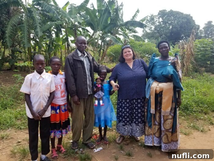 Tammilee standing with a family in Uganda