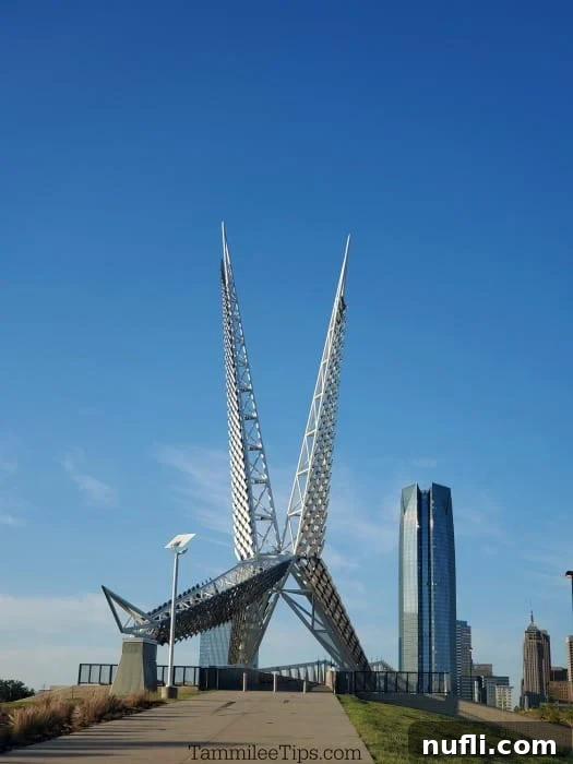 Silver skybridge towers with large sky scraper in the background