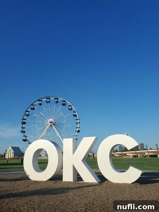 Ferris wheel behind a OKC white sign