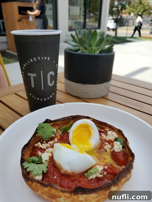 shakshuka on a plate next to The Collective cup 