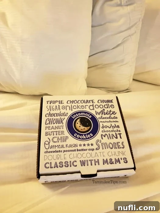 Insomnia cookies box on a white comfortor by pillows