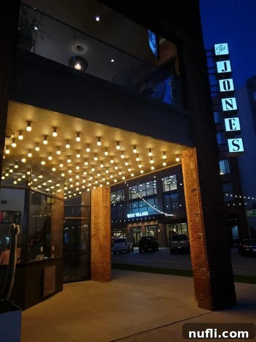 The Jones sign on the side of a buildng with lights under it 