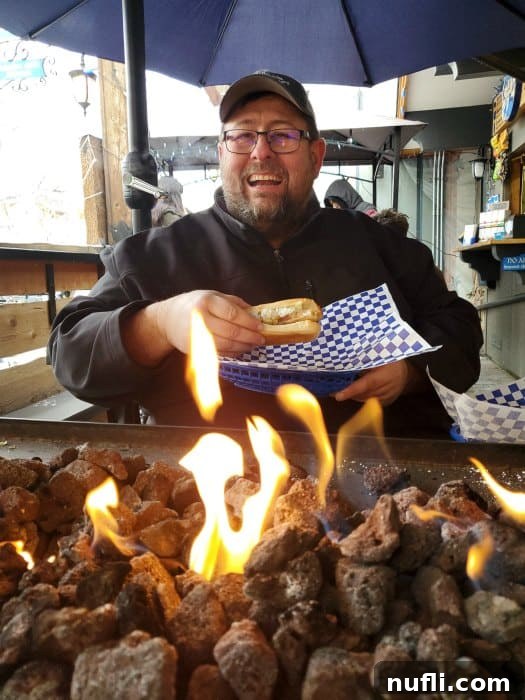John holding a bratwurst by a fire table in Leavenworth