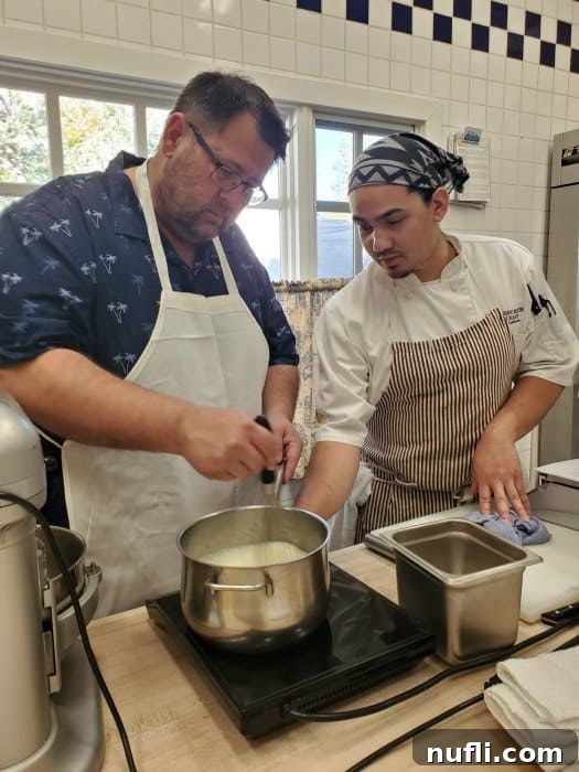 John, a cooking enthusiast, working alongside a professional pastry chef over a pot of chocolate during a sweet treats cooking class.