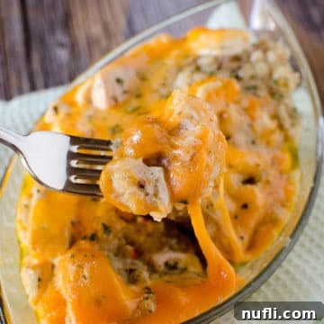 fork holding chicken stuffing casserole over a glass dish