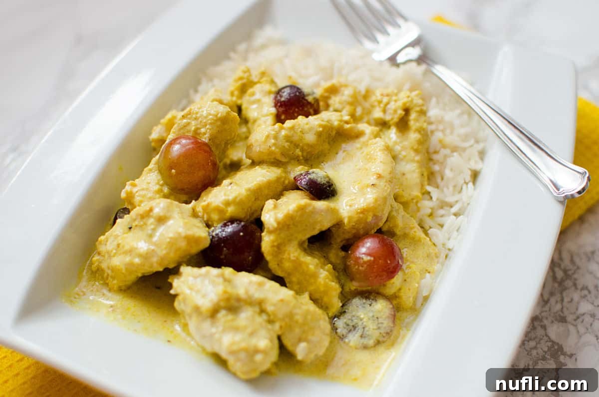 Slow Cooker Turkey Curry Delights 5 turkey curry with grapes on a white plate with a fork