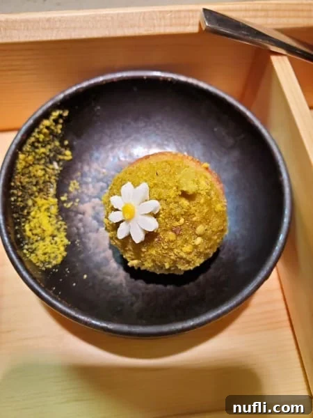 gorgeous dessert with a white flower decoration in a dark bowl 