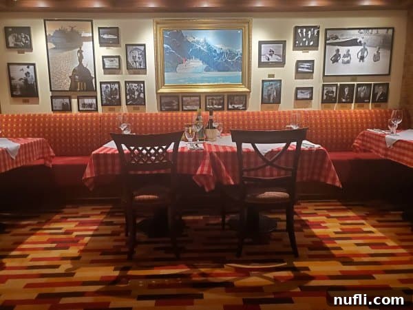 Cucina del capitano seating with red and white checkered tablecloth, pictures on the wall of Carnival ships and captains