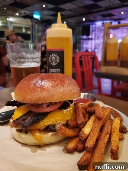 brisket sandwich next to a glass of beer and fries